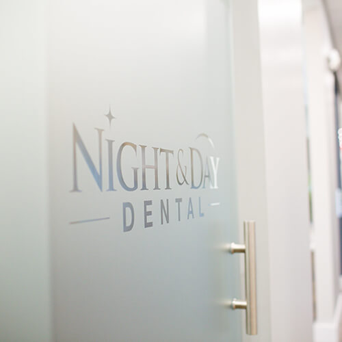 The Night & Day Dental logo on a glass door