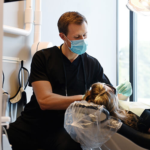 Our caring dentist showing real concern for a patient while looking in their mouth