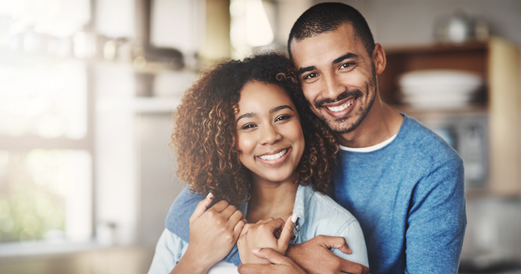 A couple embrace and smile brightly